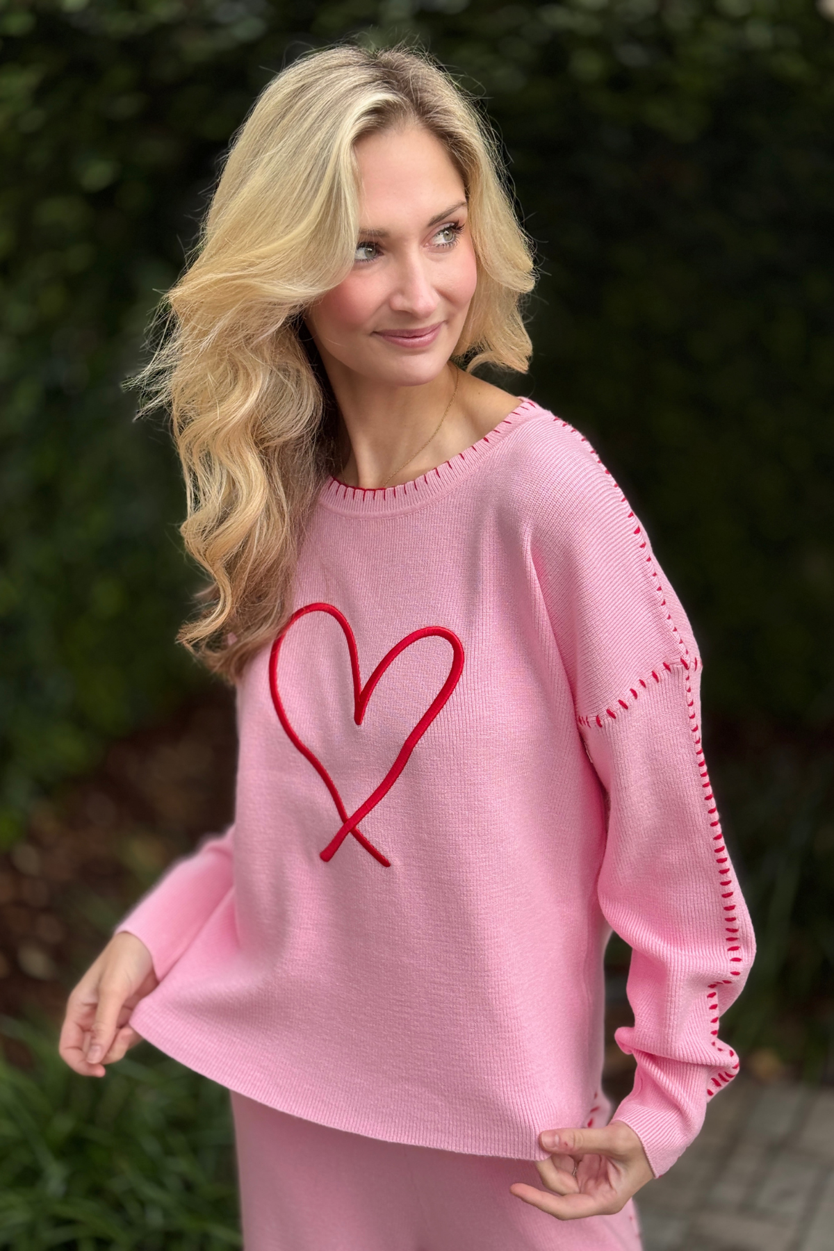 Heart embroidery detail on pink sweater top