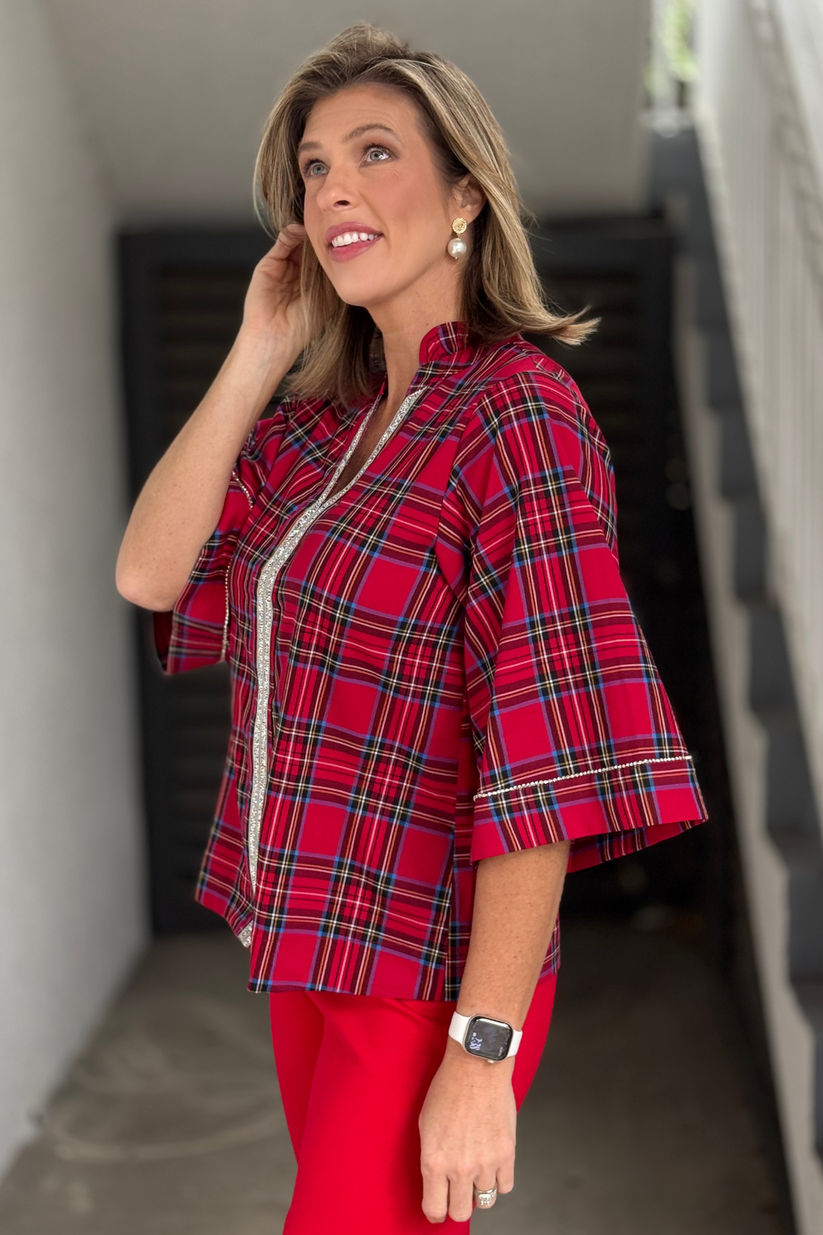 Holiday plaid blouse styled with red pants for Christmas