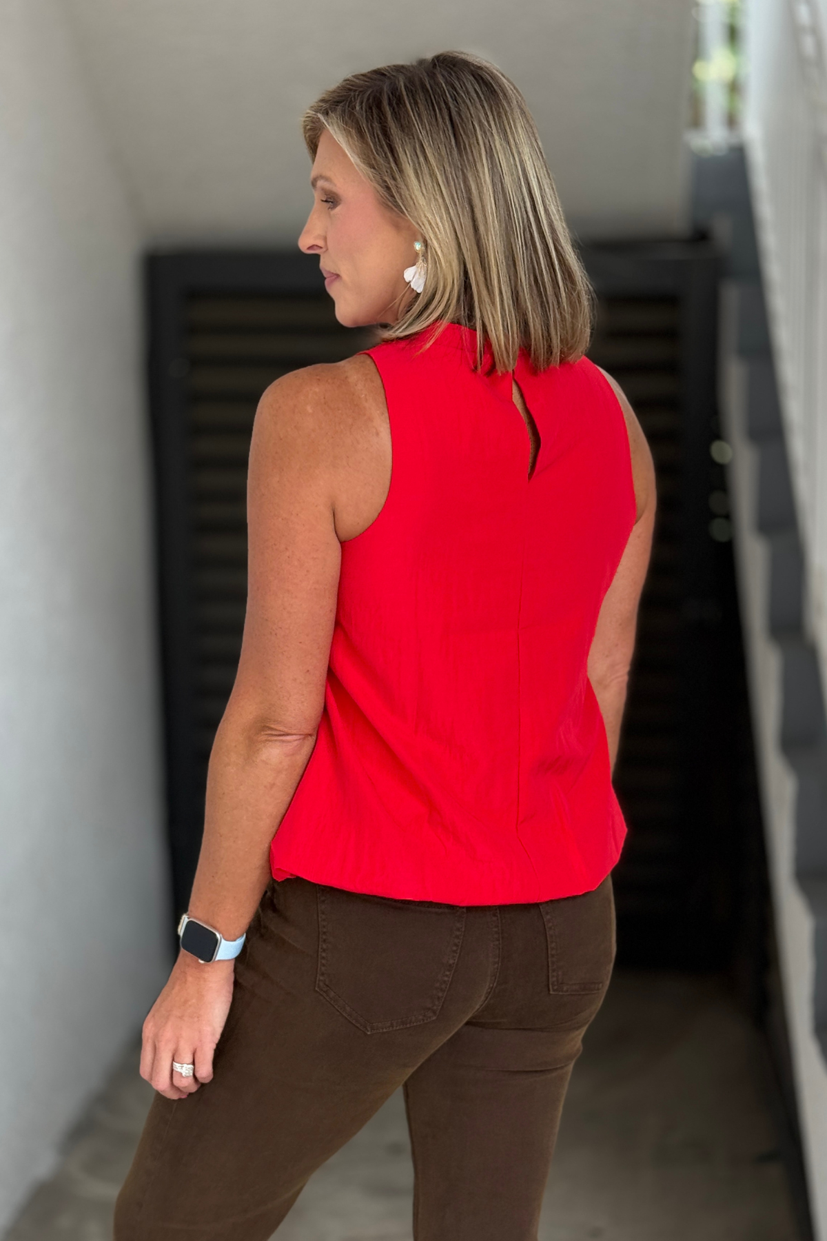 Back view of the red sleeveless bubble hem blouse.