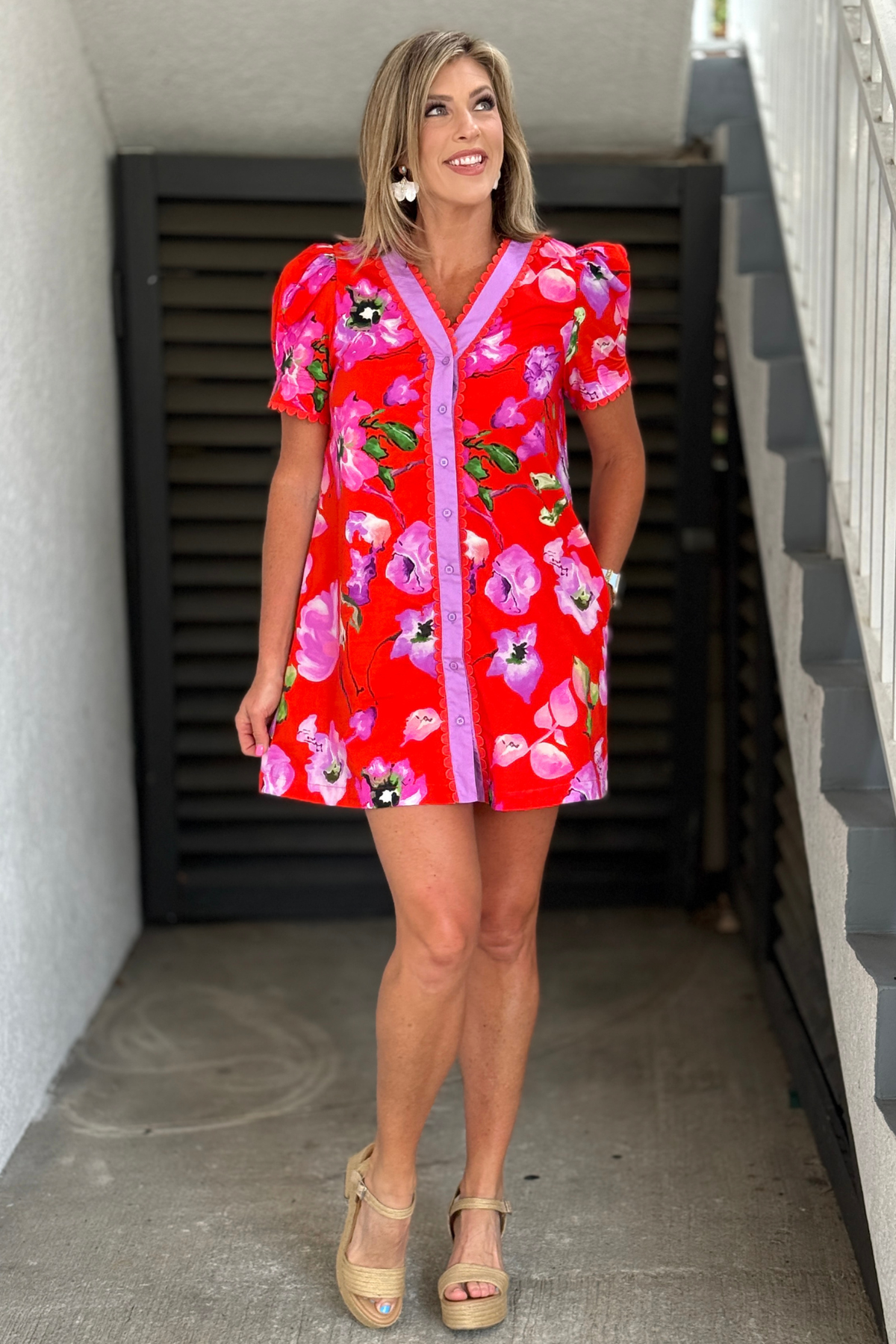 Woman wearing red floral puff sleeve shift dress with scallop trim