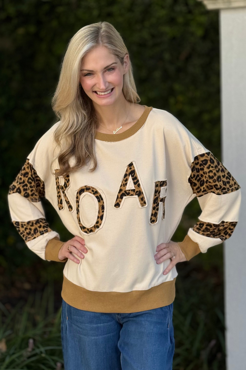 Front view of model wearing ROAR Leopard Appliqué Colorblock Sweatshirt with leopard sleeve panels