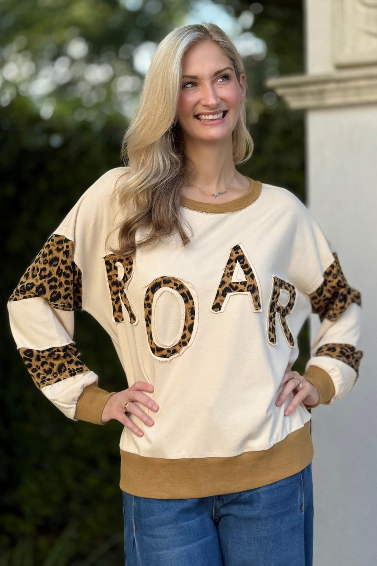 Side view of sweatshirt showing colorblock sleeves with leopard-print accents