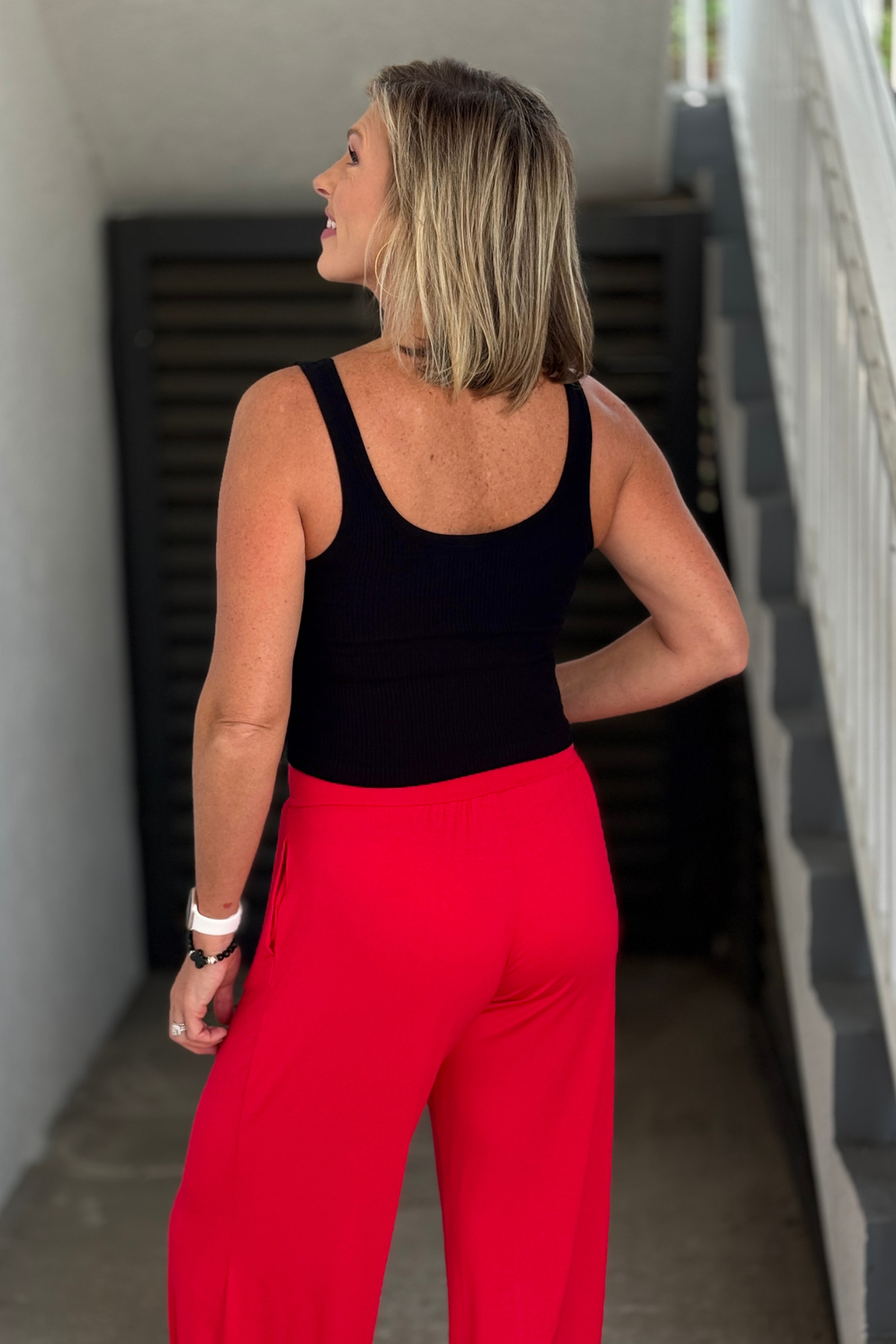 Women’s black fitted ribbed tank paired with bright pants
