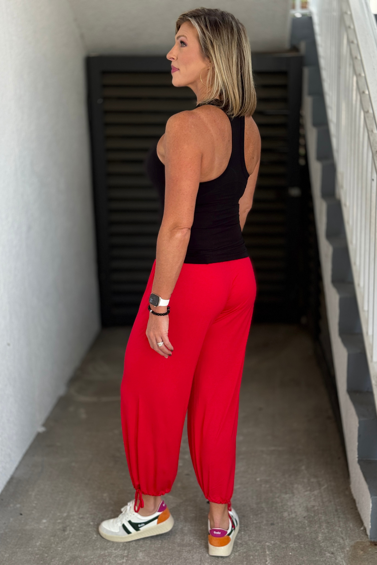 Black built-in bra tank styled with bright red relaxed pants