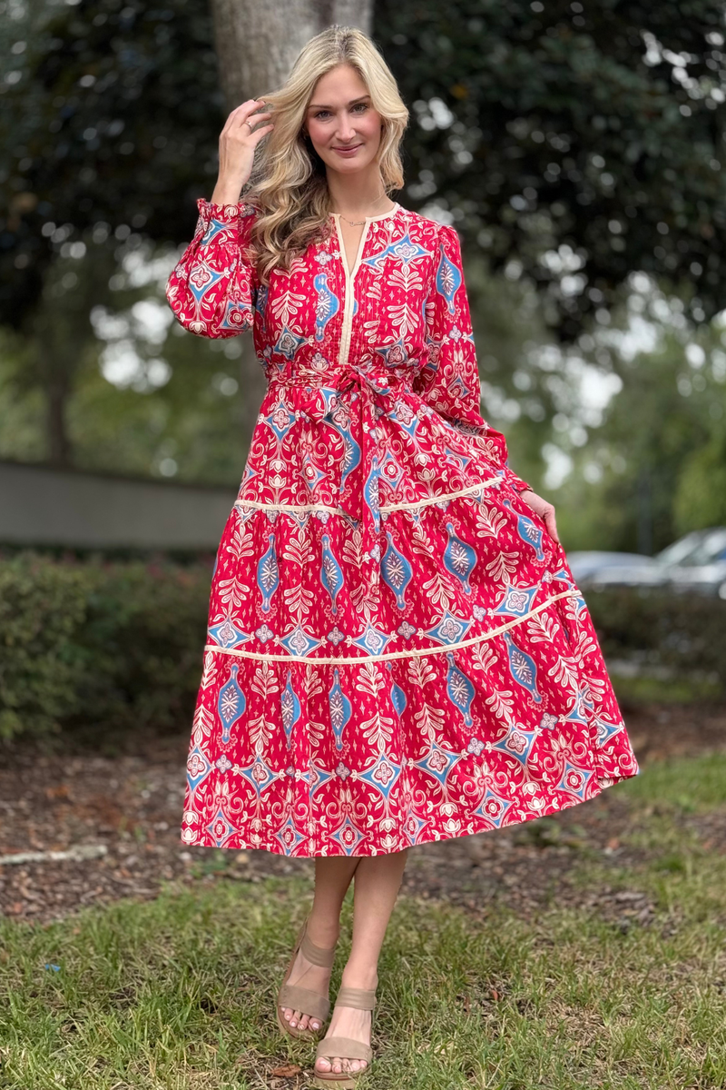 Woman wearing The Marseille Printed Midi Dress in red and blue with tiered skirt and tie waist
