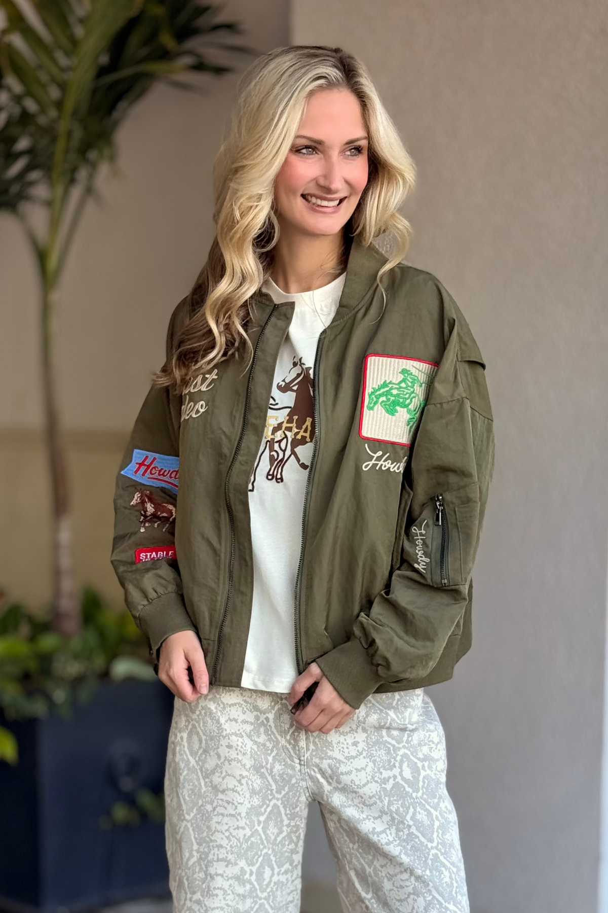 Front view of The Rodeo Rambler Embroidered Bomber in olive with western patches
