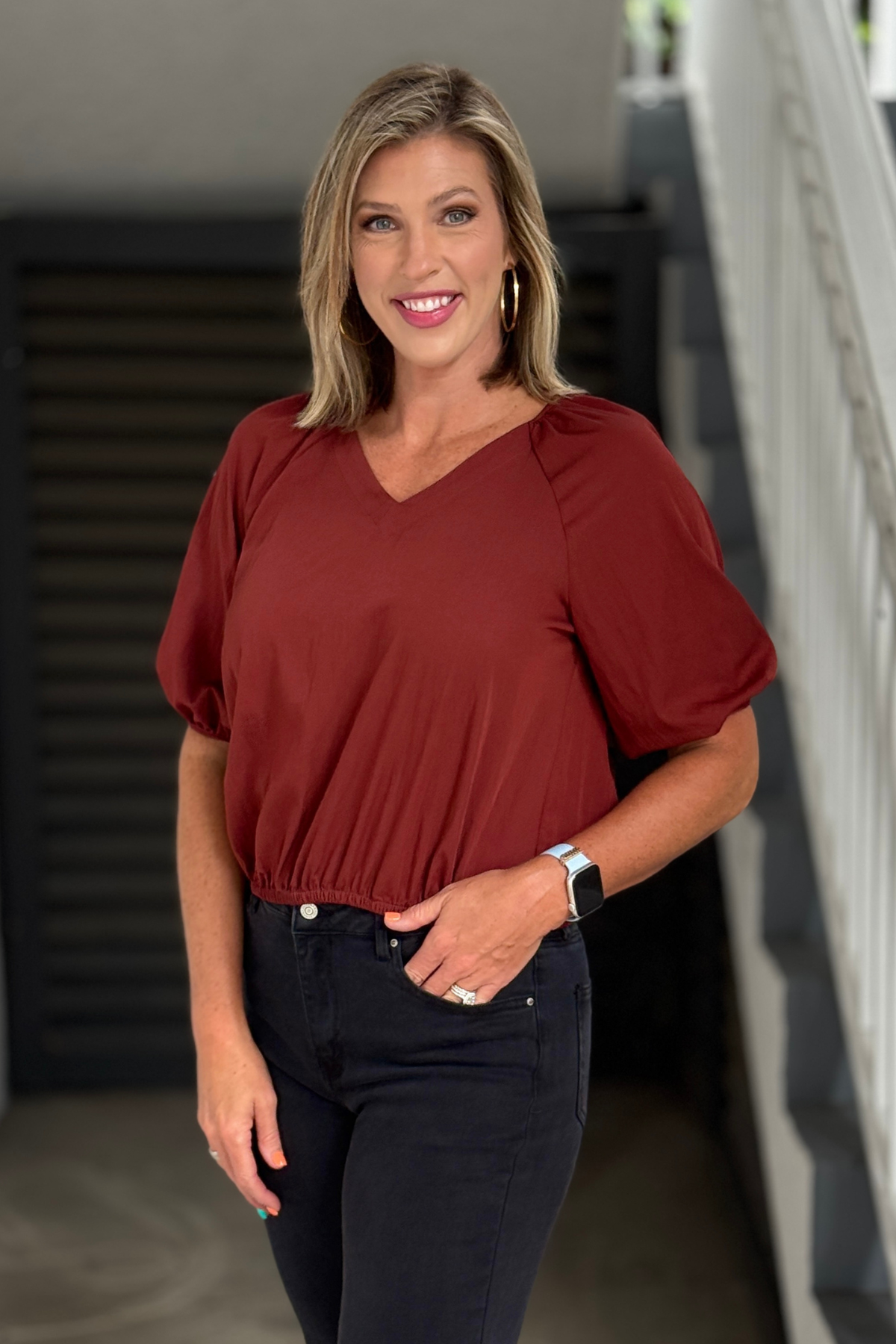 Rust V-neck blouse styled with black jeans