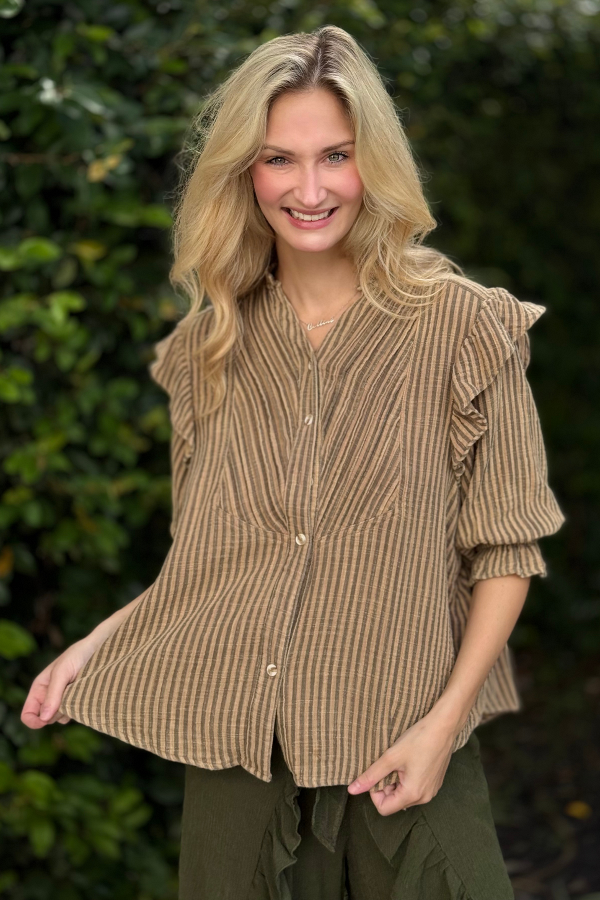 Stripe cotton gauze button down blouse with mineral wash, ruffle trim V-neckline, front pleats, and ¾ sleeves with elastic cuffs.