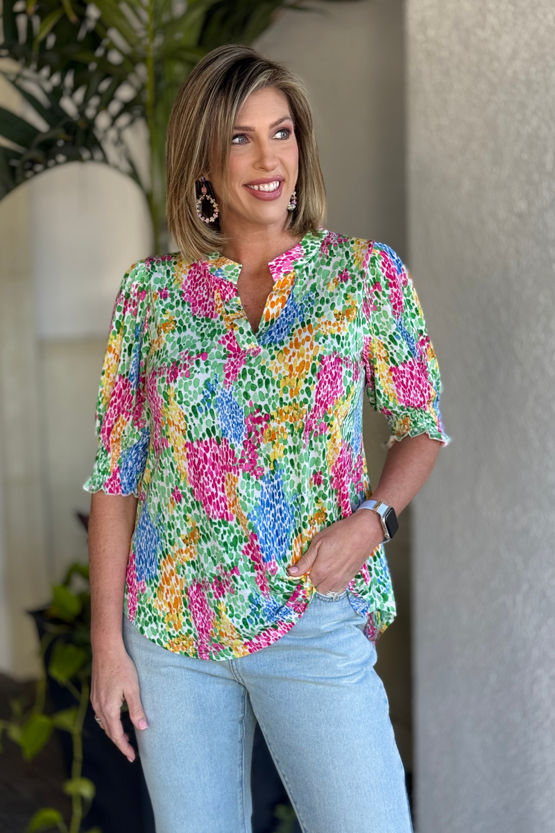 Multicolor wrinkle-free smocked short sleeve top styled with light wash jeans
