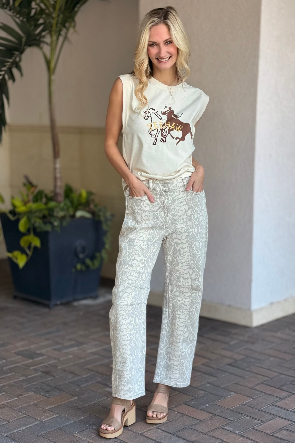 Model wearing white-wash snake print barrel pants with hands in pockets