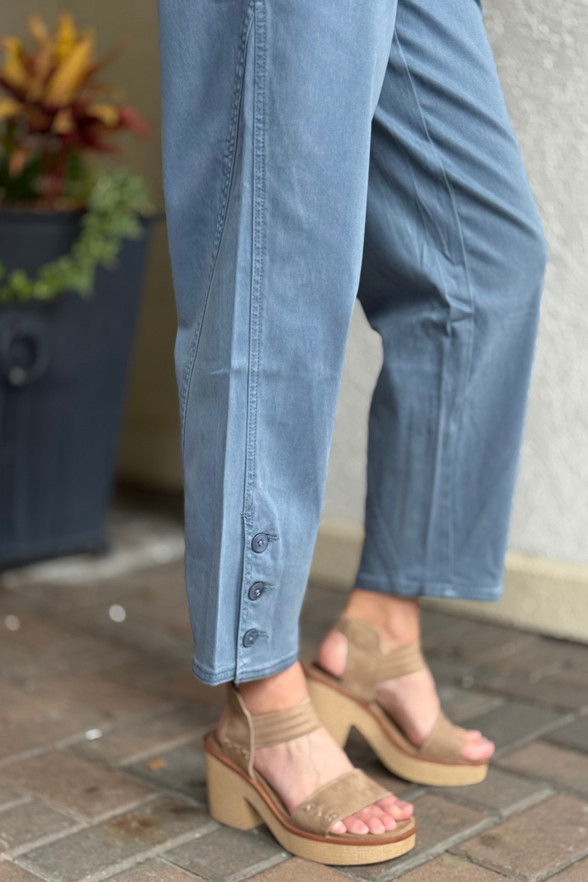 Close-up of ankle-length twill pant with porkchop pockets and marbled button closure