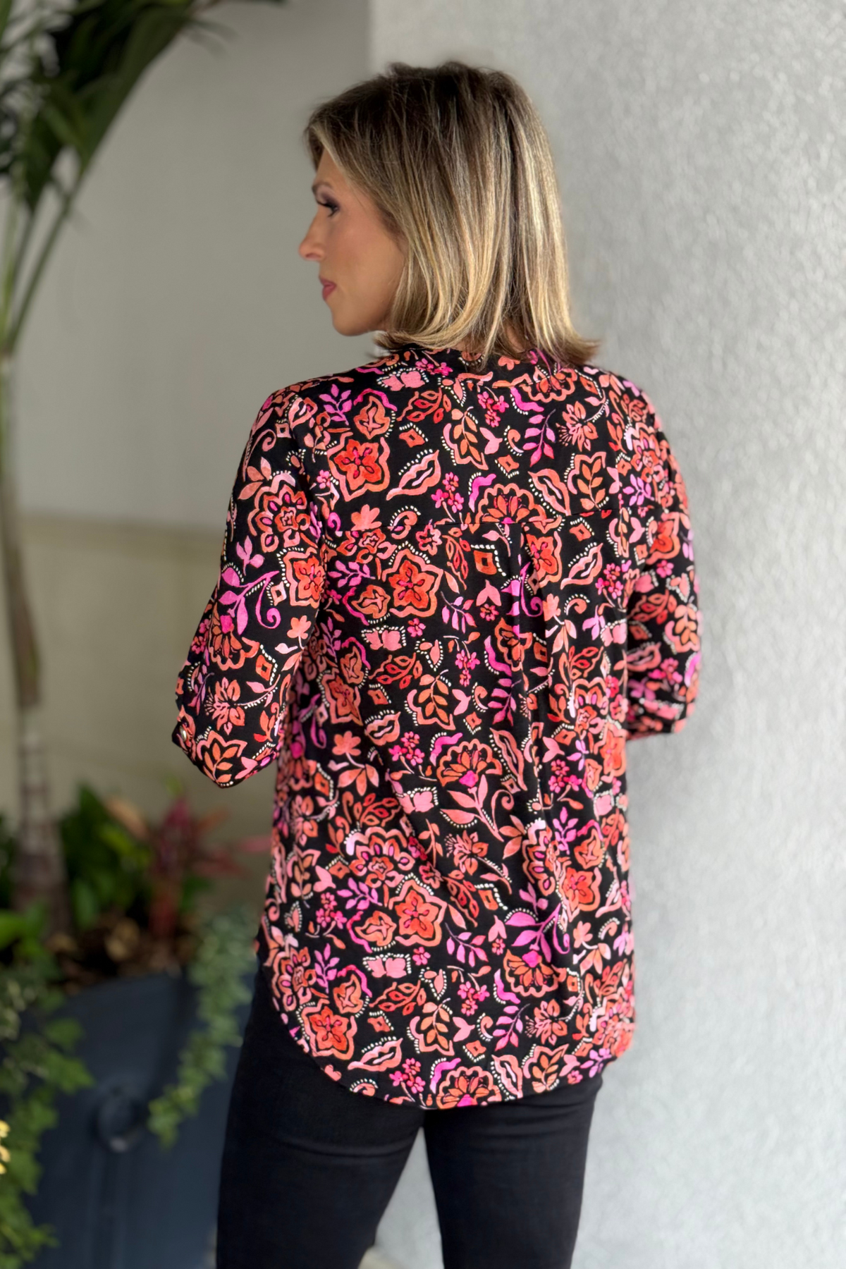 Side view of the TPN Jetsetter Floral Printed Top in black showing high-low hem and relaxed fit.