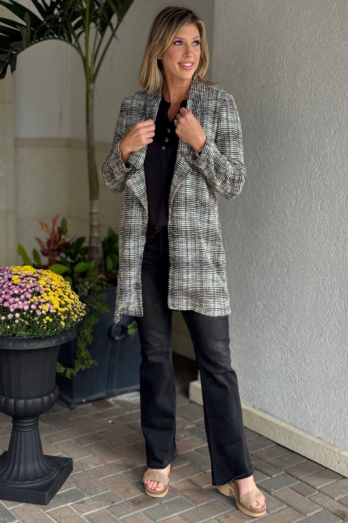 Woman wearing the TPN Brixton Tweed Midi Blazer in textured black and white tweed.
