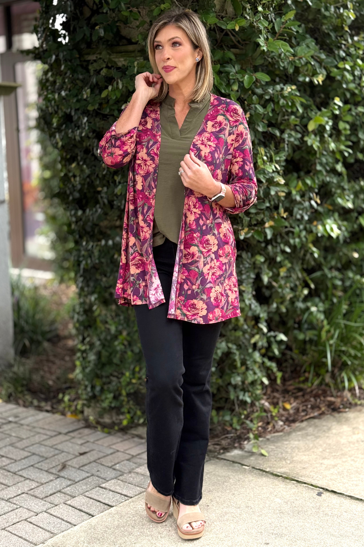 Model wearing TPN Bloomed in Beauty Cardigan featuring a pink and plum floral print made from wrinkle-free Bulgari fabric.