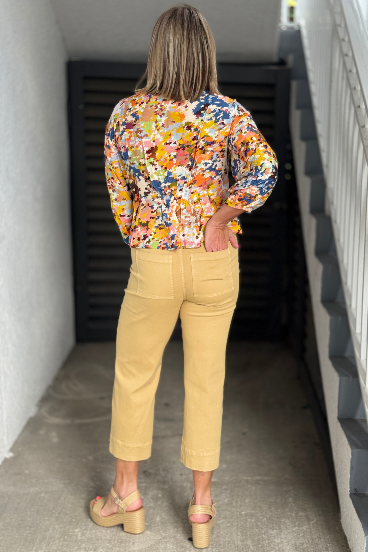 Side view of women's tan straight leg crop jeans paired with platform sandals for a polished casual outfit.