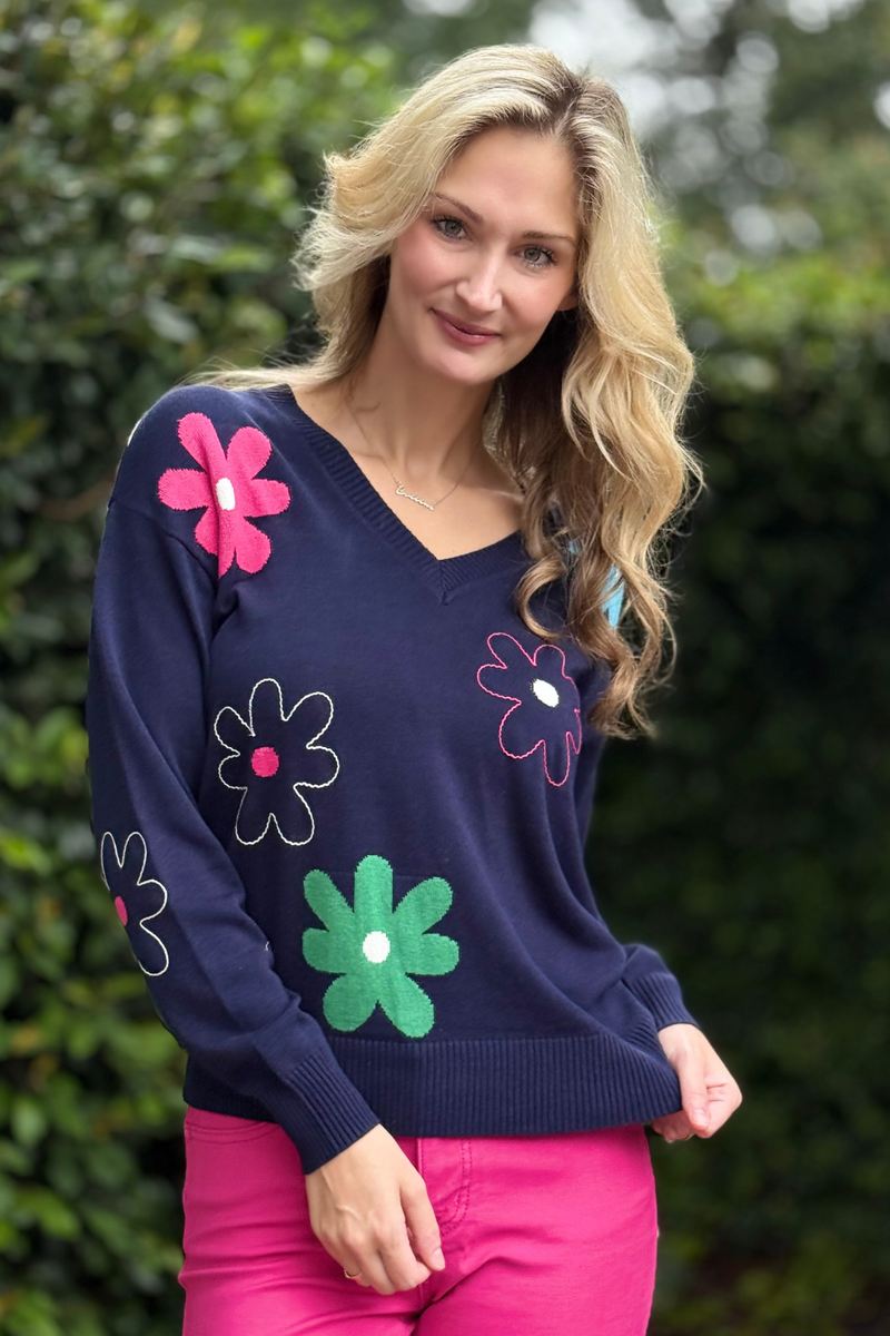 Close-up of daisy embroidery detail on cotton knit sweater