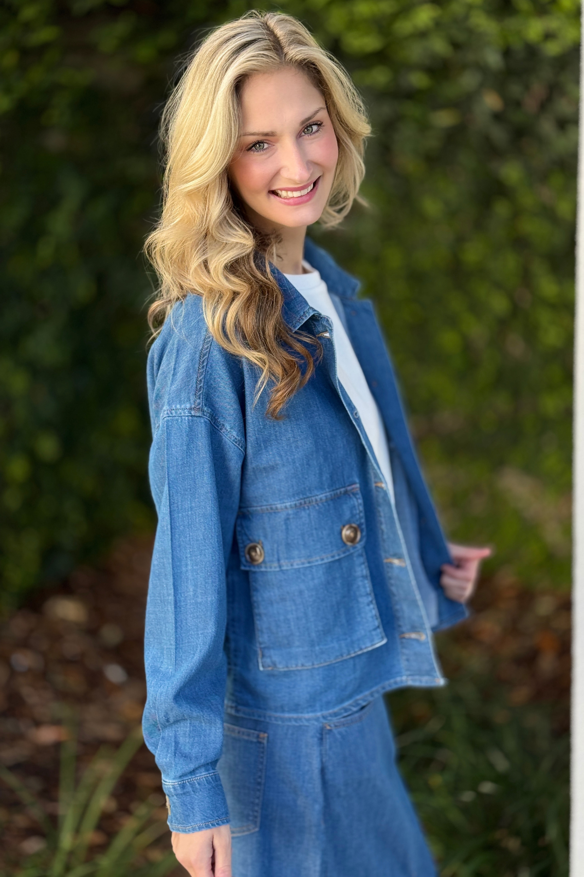 Woman styling Tribal Fjord Blue denim jacket layered over casual outfit