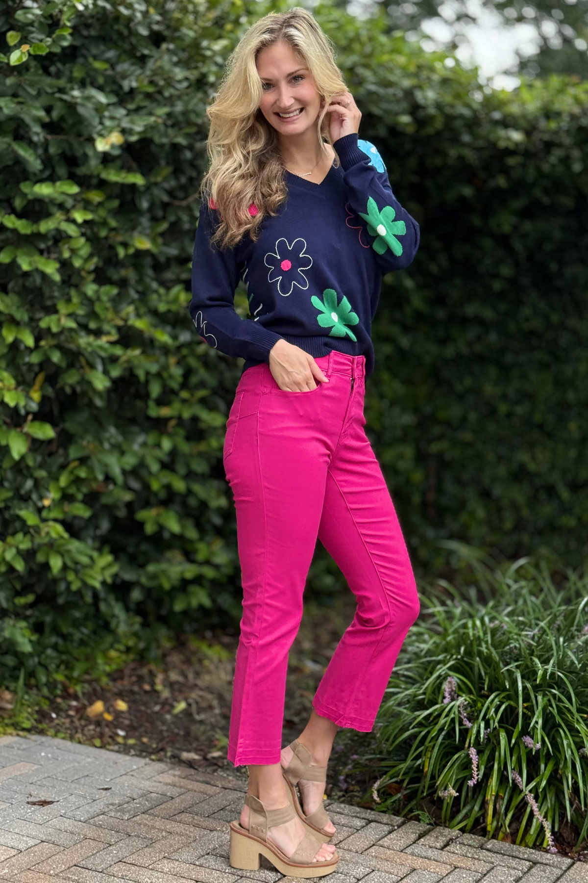 Side view of curvy-fit pink crop jeans styled with wedges