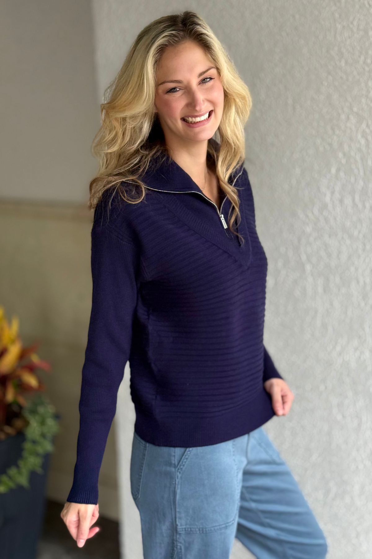 Close-up of soft-touch navy knit sweater with zipper detail