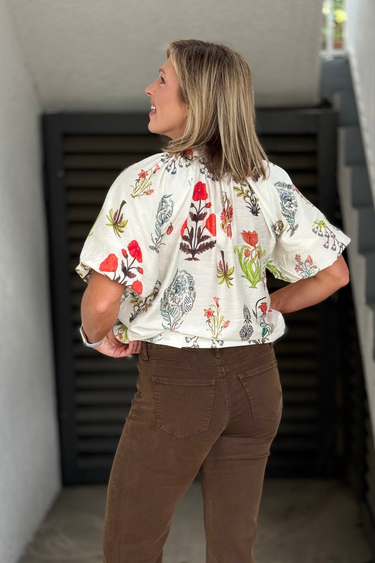 Back view of the botanical print blouse showcasing the relaxed silhouette and lightweight woven fabric.