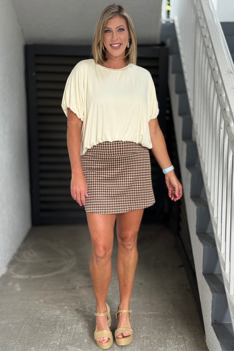 Woman wearing the Brown Gingham Plaid Skort with an ivory bamboo top.
