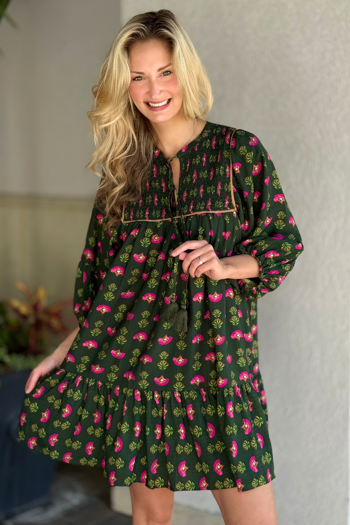 Model wearing a hunter green floral boho mini dress with mixed prints and relaxed fit.