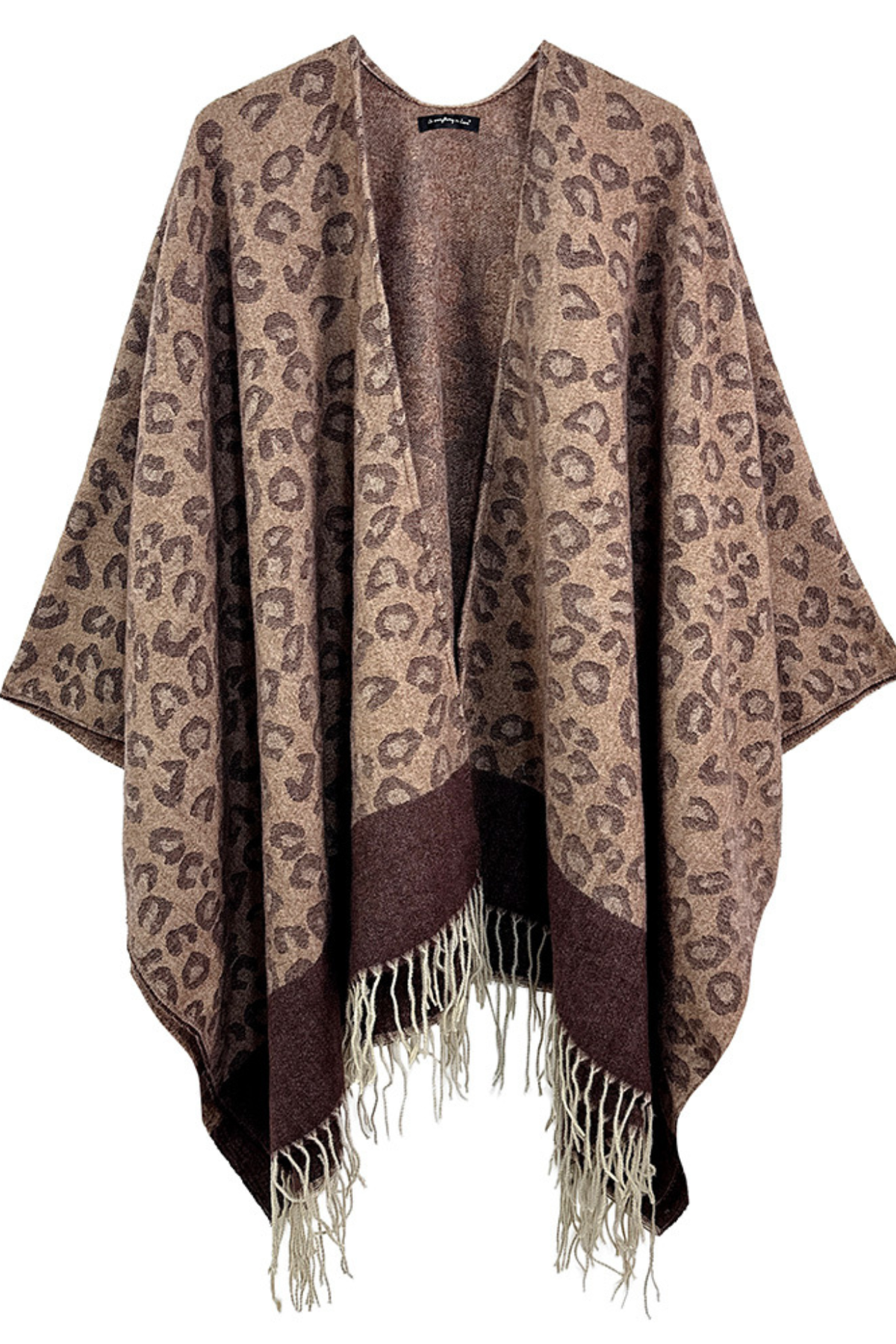 Woman wearing The Luxe Leopard Fringe Poncho styled with shorts and boots.