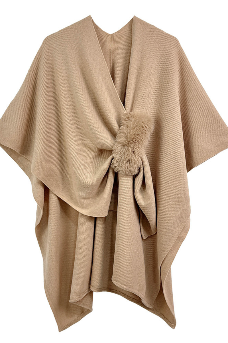 Camel knit ruana poncho with faux fur pom detail, draped open-front design.