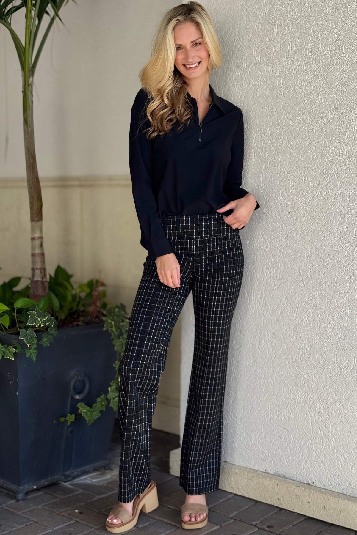 Woman wearing black and white windowpane check Liverpool Pearl Flare pants with a sleek pull-on fit