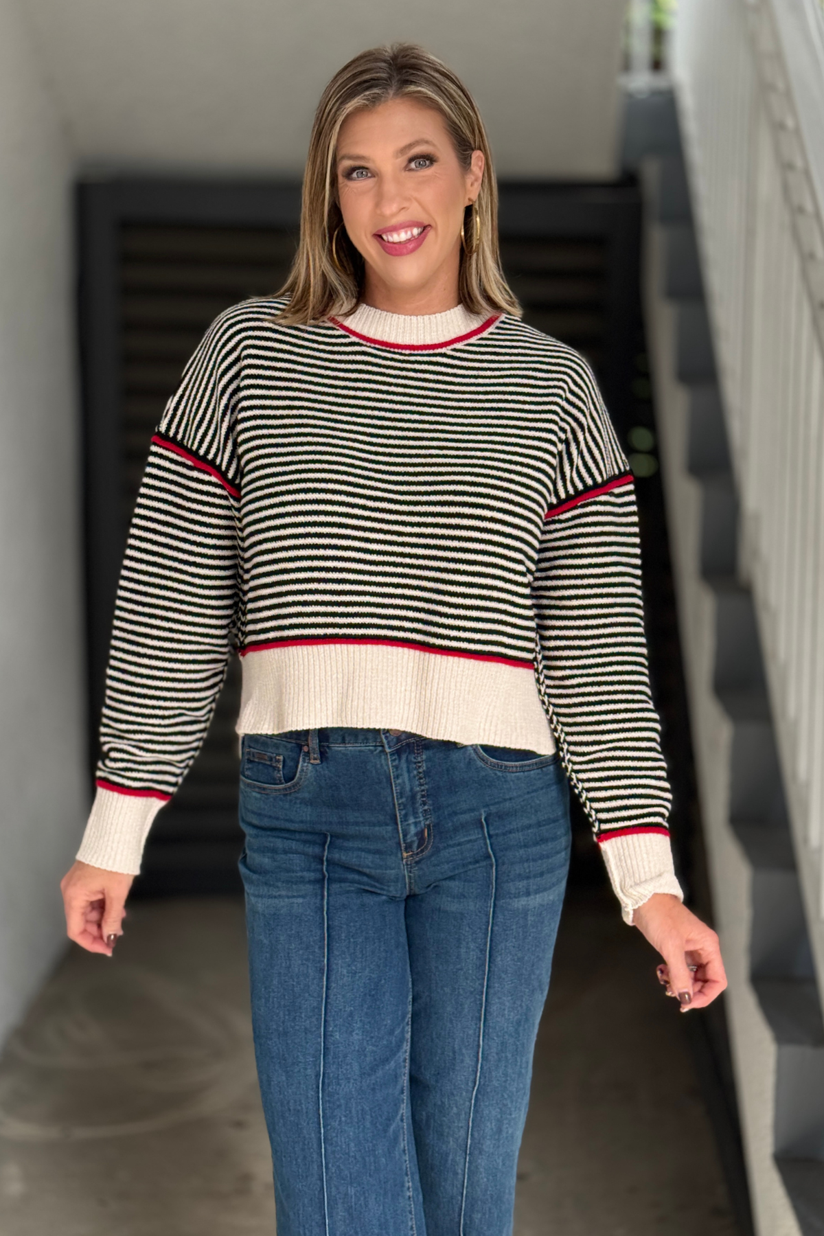 Women’s black and cream striped sweater with red contrast trim