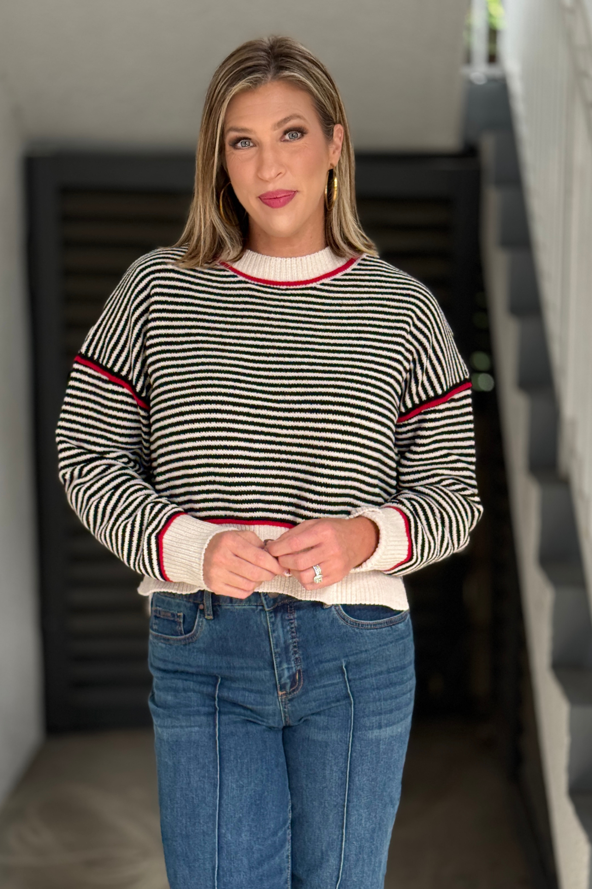 Back view of black cream and red striped knit sweater