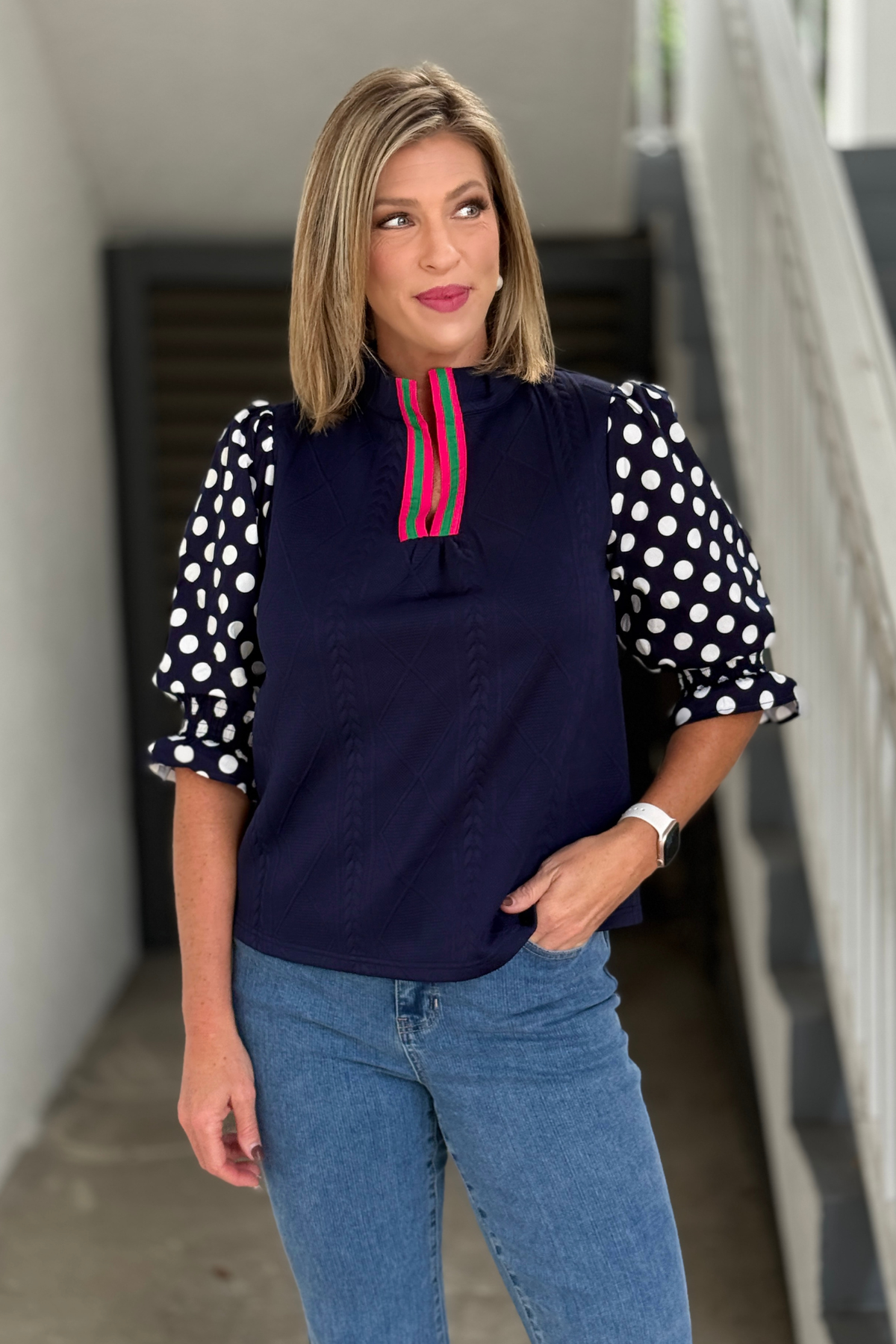 Navy textured knit top with navy and white polka dot puff sleeves