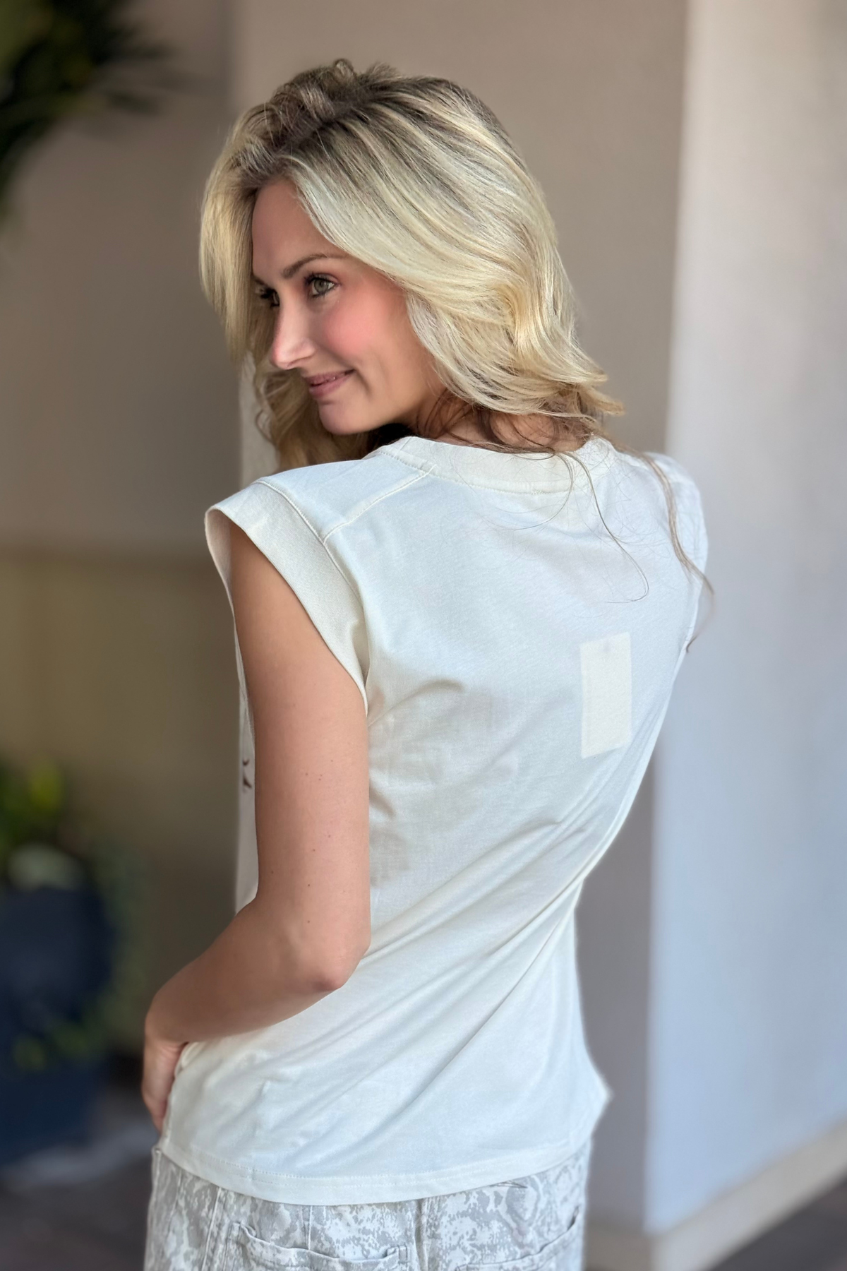 Back view of cream boxy western tank top on model