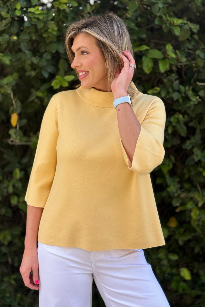 Back view of yellow mock neck knit sweater with relaxed fit