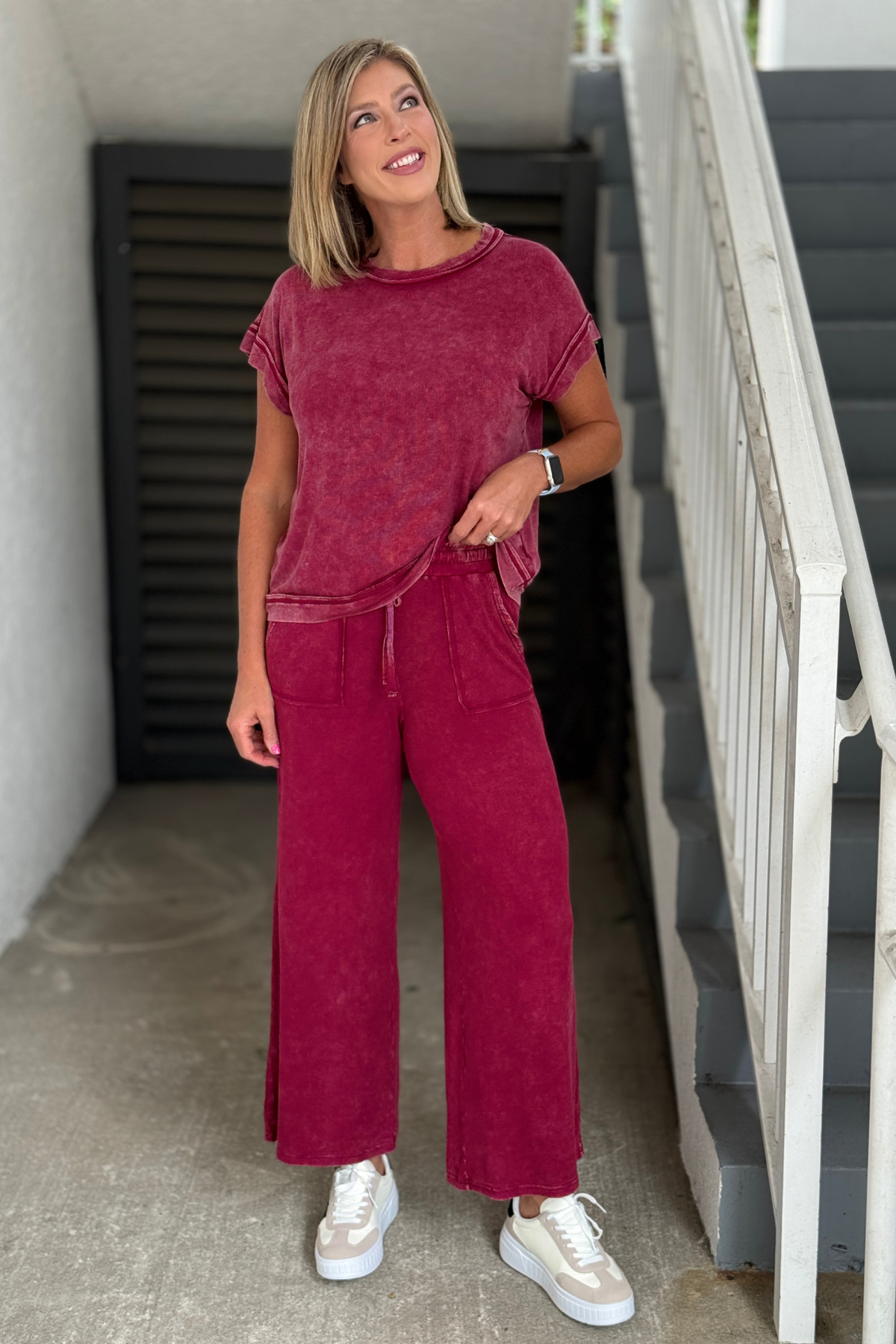 Woman wearing the Mineral Wash Wide Leg Lounge Set in Cabernet with white sneakers front view.