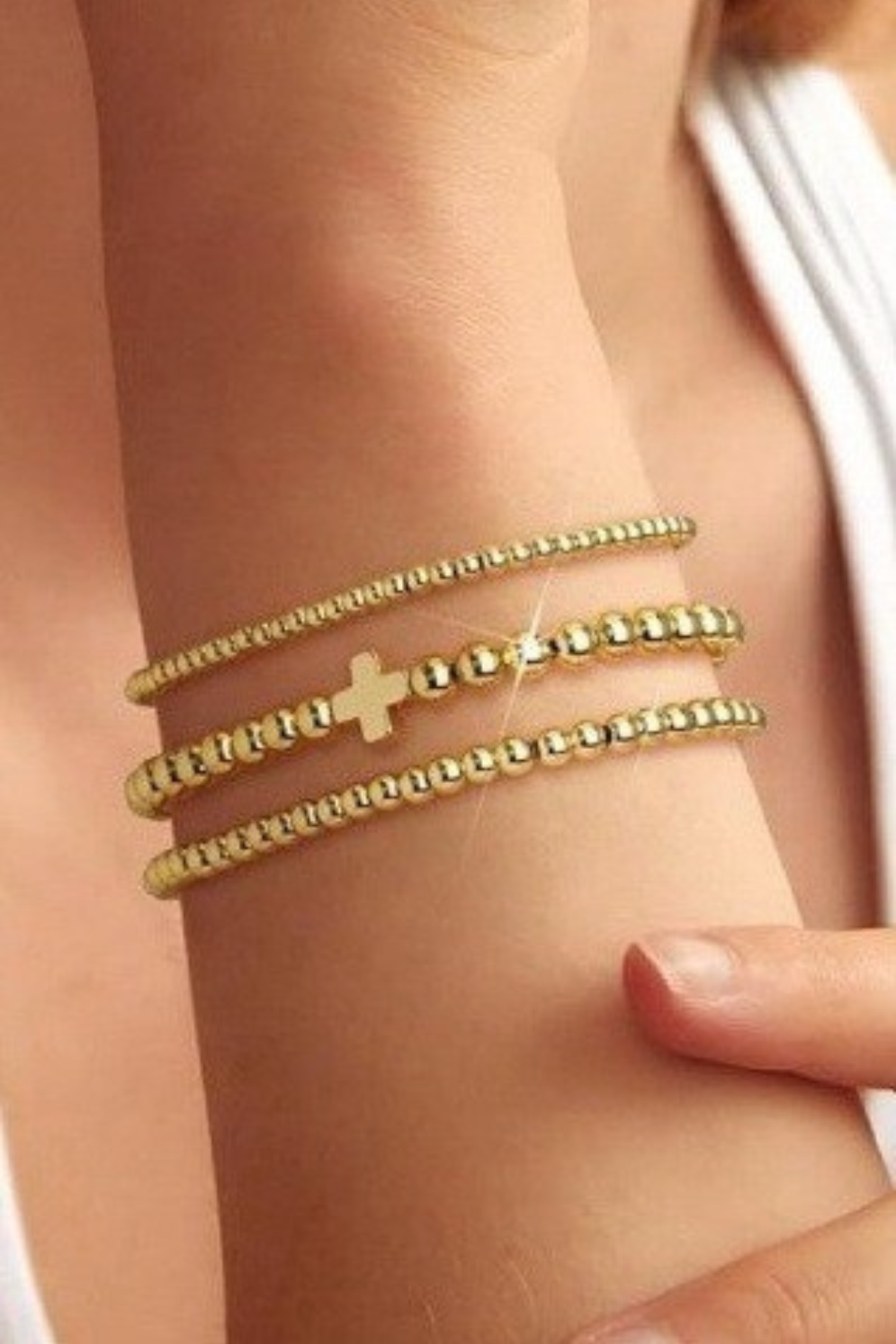 gold multilayer cross ball chain bracelet on wrist