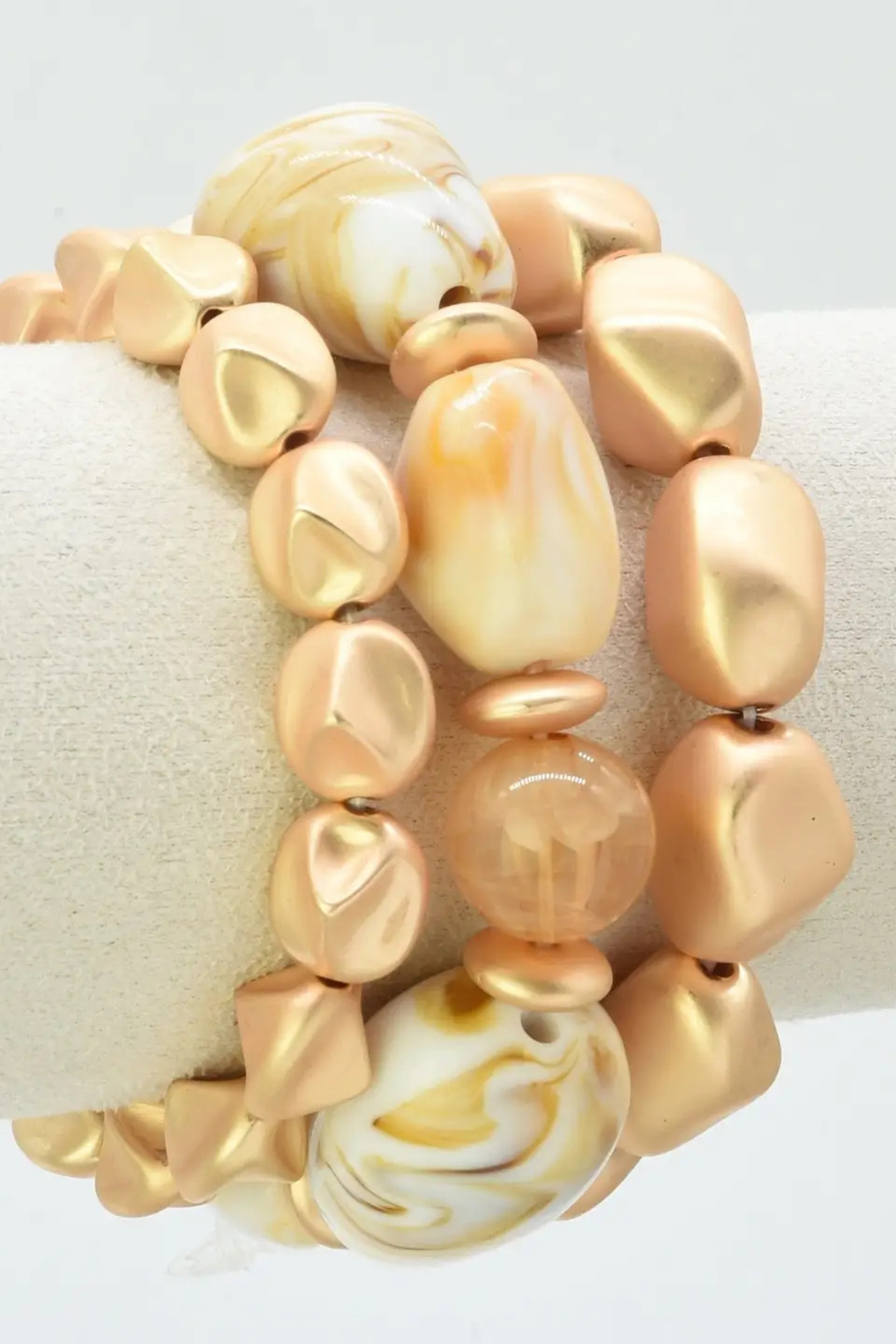 Gold and nude stretch bracelet stack with marbled accent beads
