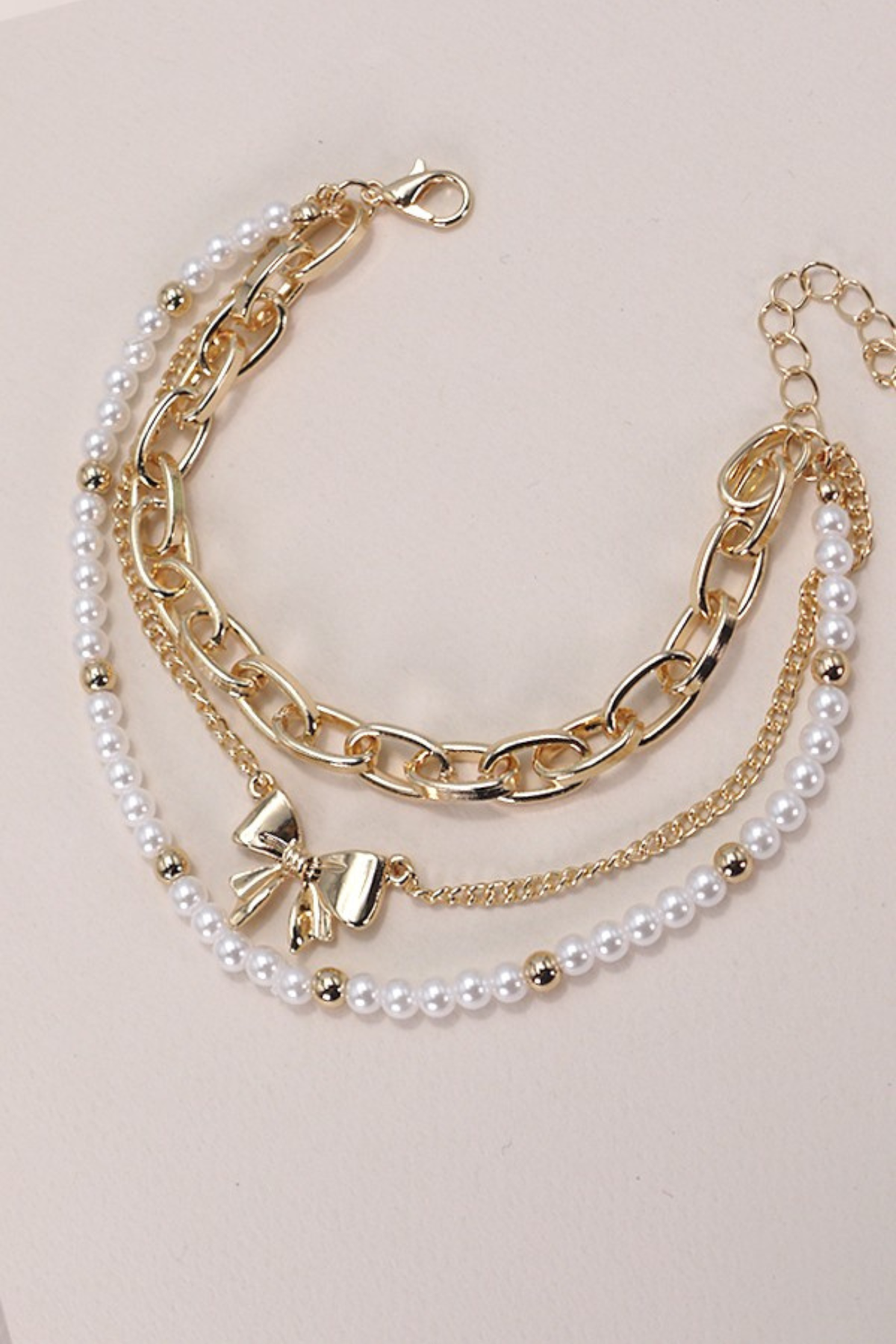 layered pearl and gold bow charm bracelets