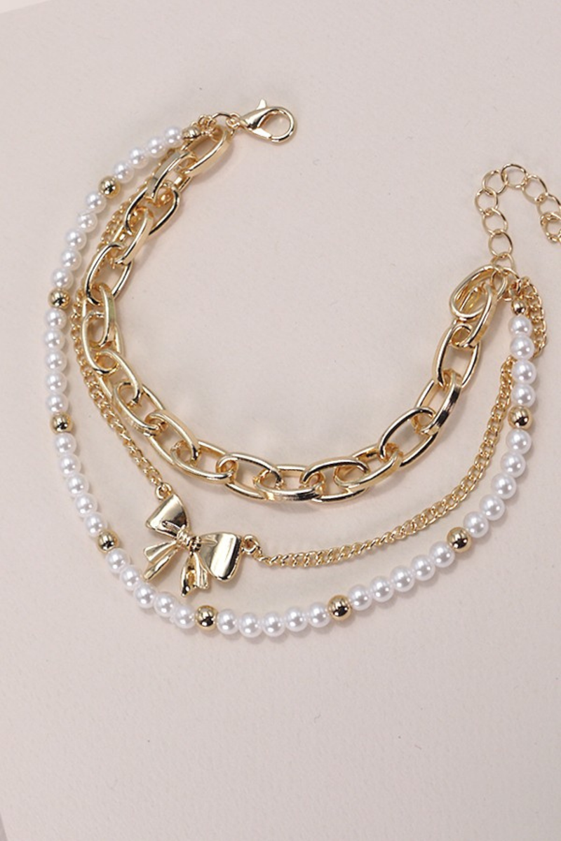layered pearl and gold bow charm bracelets