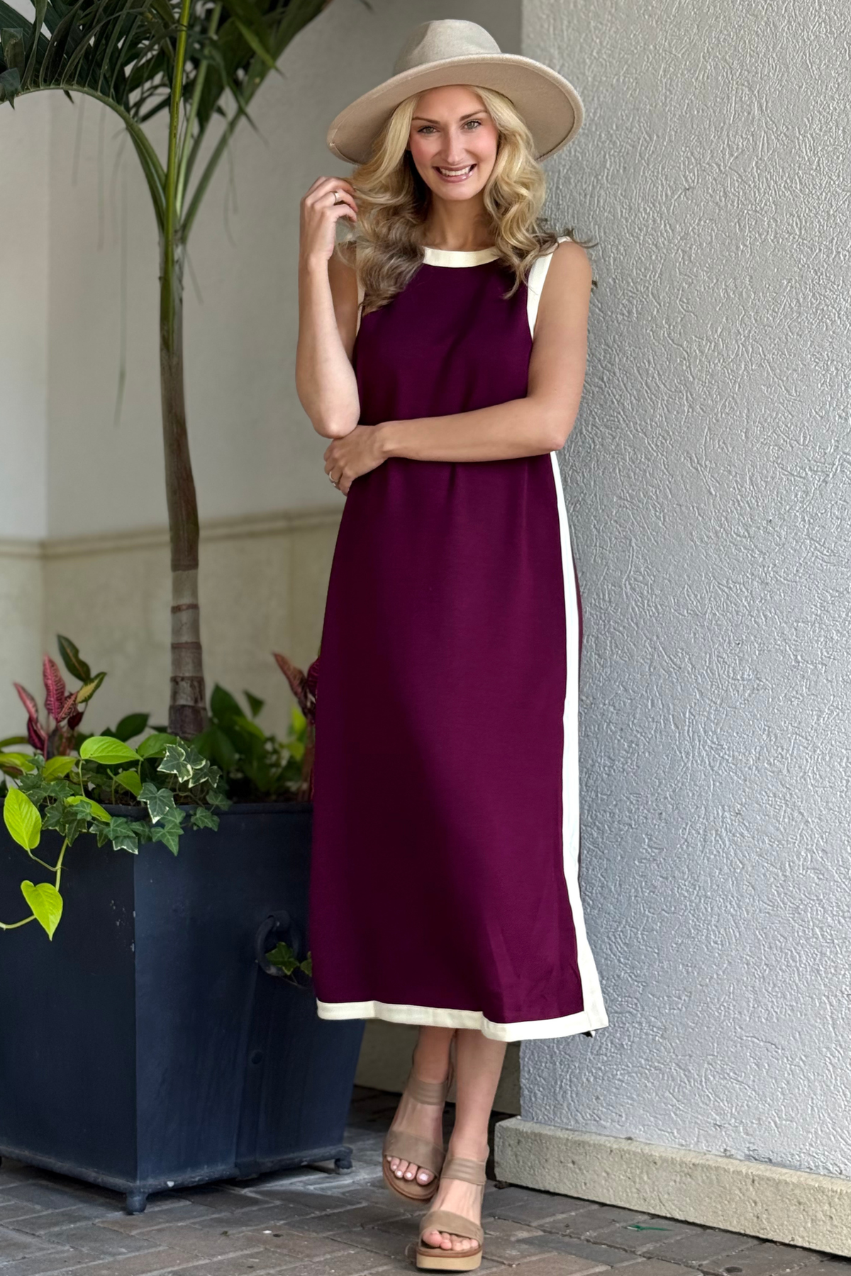 Sleeveless burgundy midi dress styled with nude heels and a neutral hat from The Pink Nickel