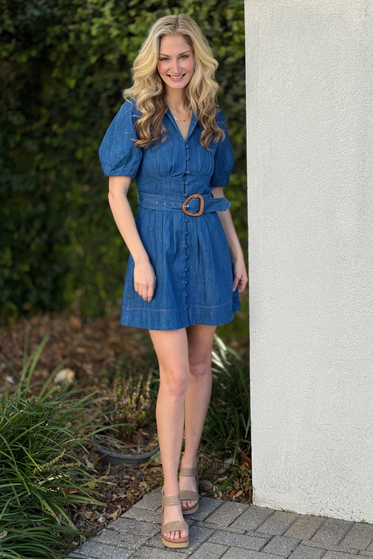 Side view of denim belted mini dress showing fitted waist silhouette