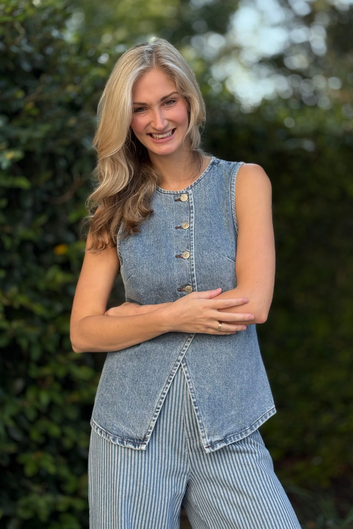 Front view of model wearing The Westwood Classic Denim Vest with metal button closures