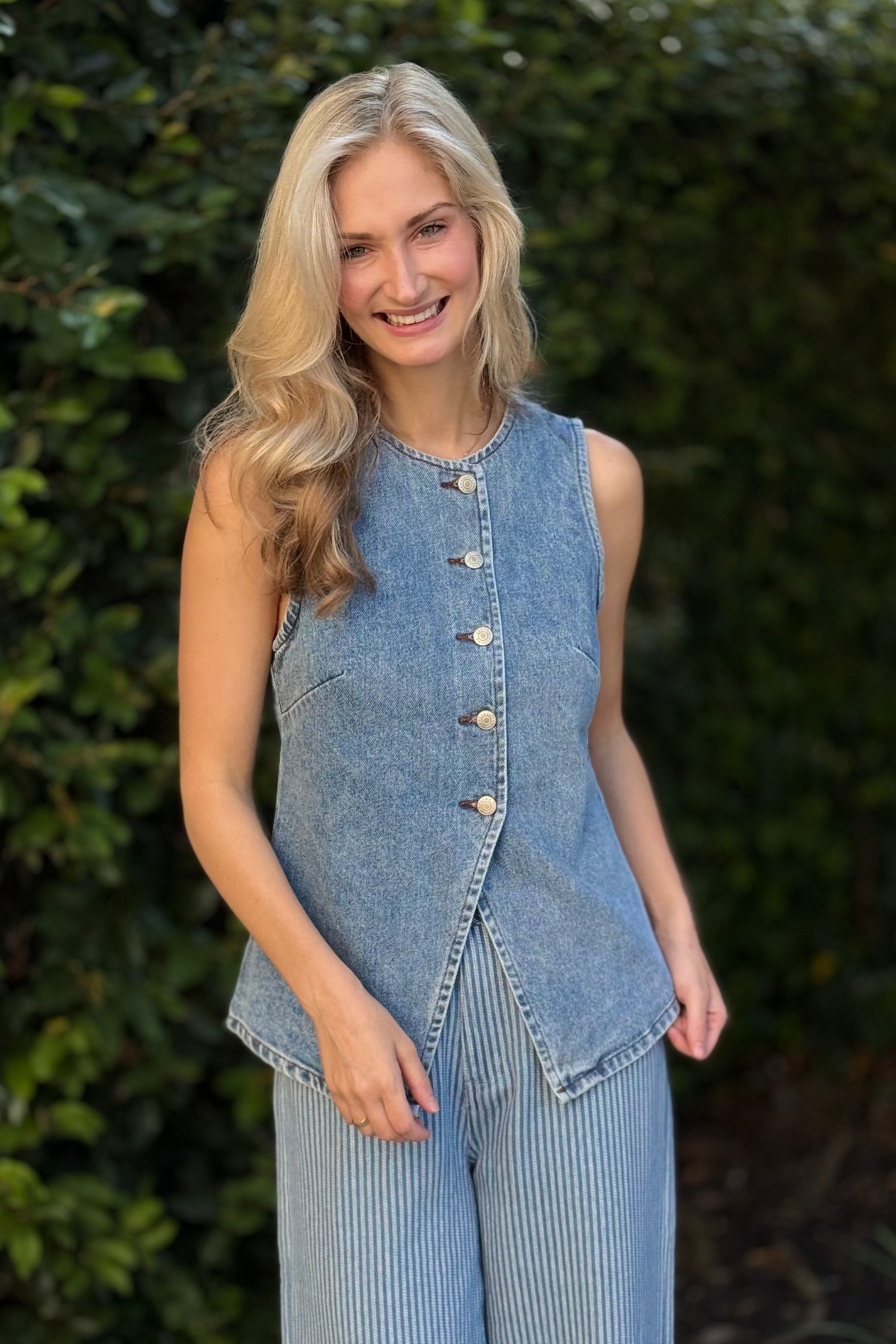 Back view of sleeveless denim vest with soft princess seams and vintage wash