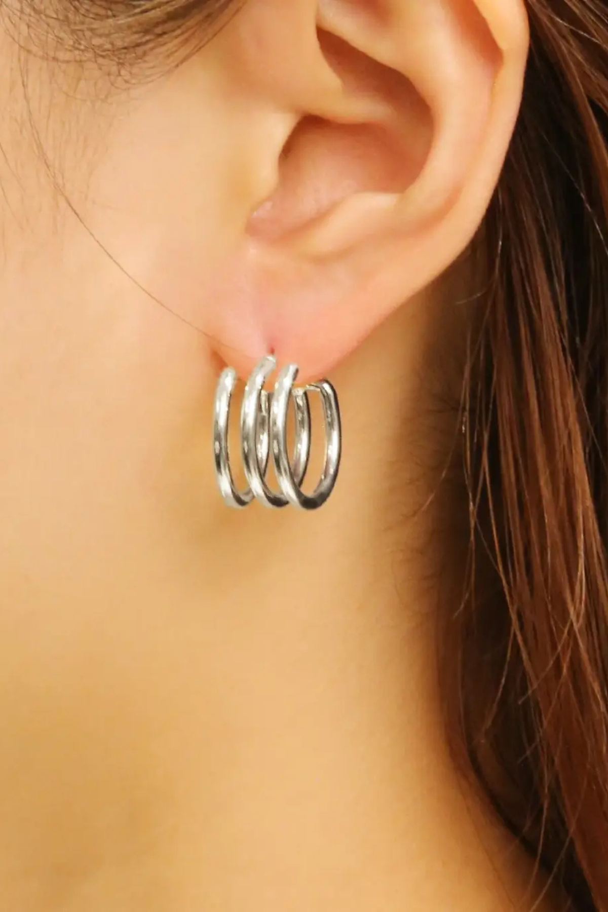 Silver layered hoop earrings on model
