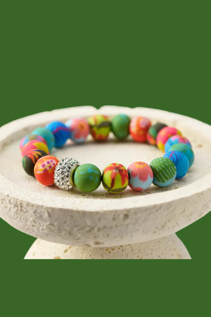 Paradise Island Crystal Stretch Bracelet featuring colorful handcrafted polymer clay beads, sparkling crystal centerpiece, and matte gold accents.