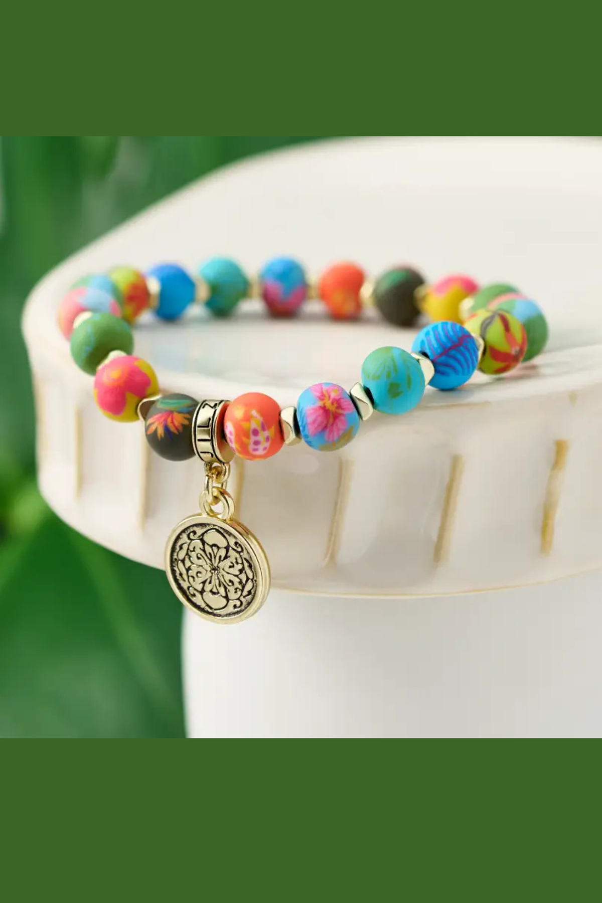 Colorful Paradise Island Petite Blossom stretch bracelet with handcrafted floral polymer clay beads, matte gold accents, and a floral charm.