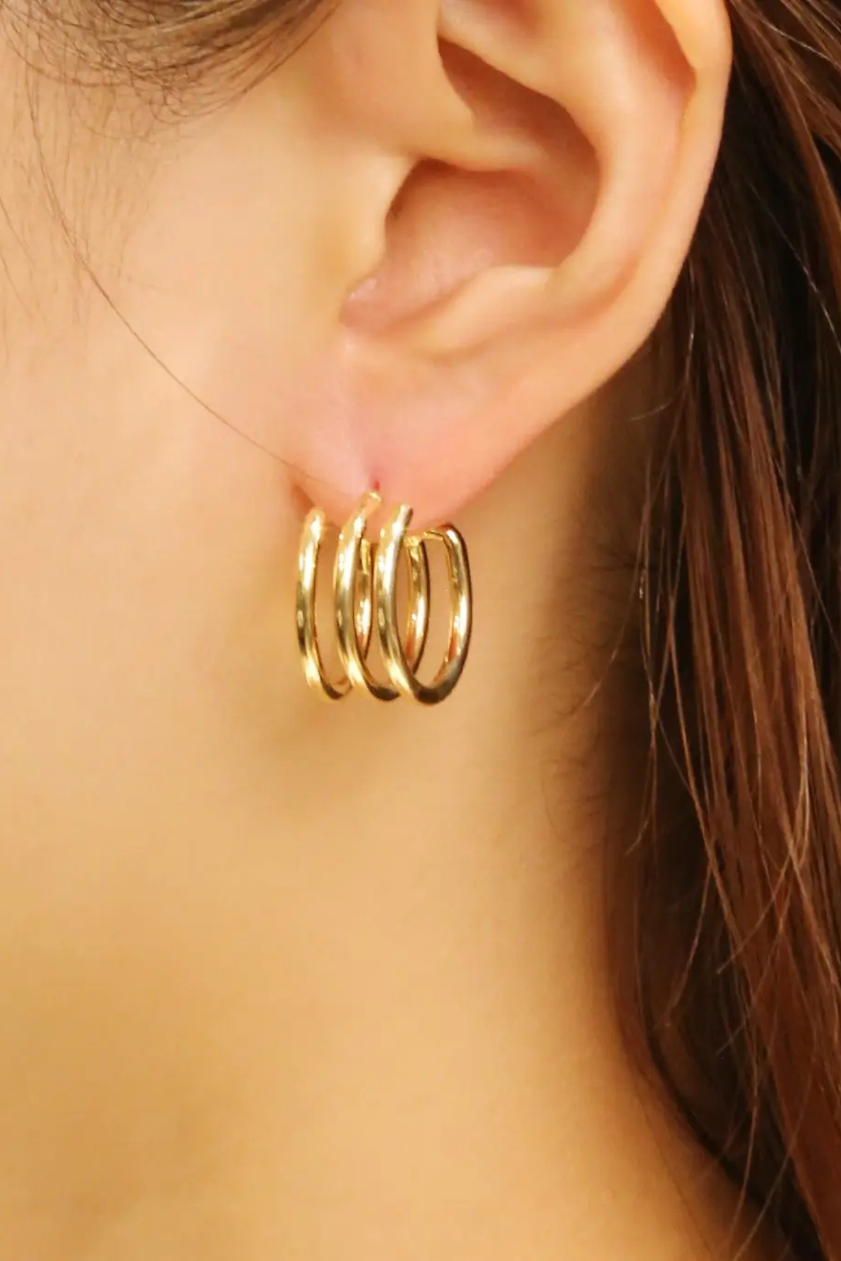 Gold triple hoop post earrings close-up