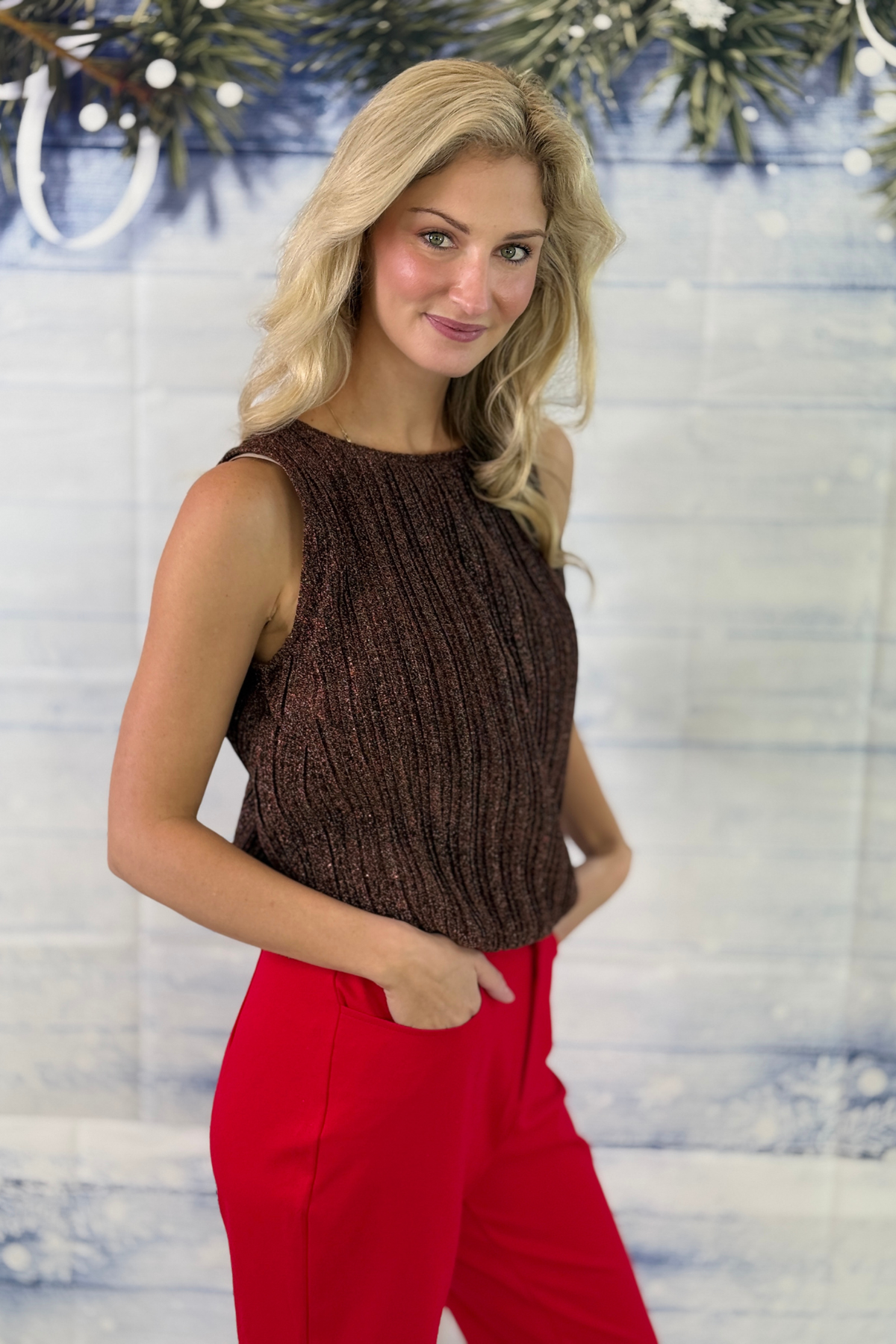 Women’s metallic knit top styled with red pants
Bronze holiday top with blouson hem
