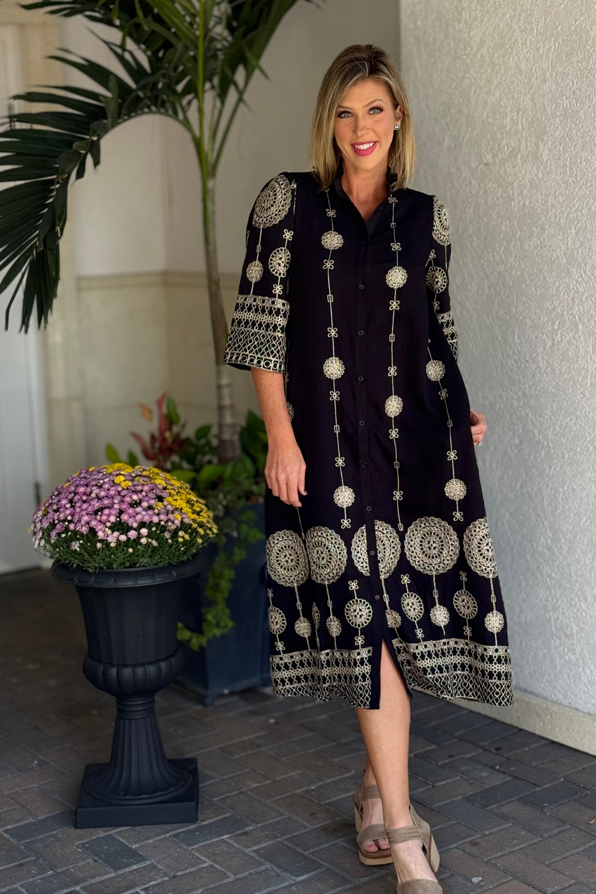 Close-up of metallic embroidery and ruffled collar on black midi dress