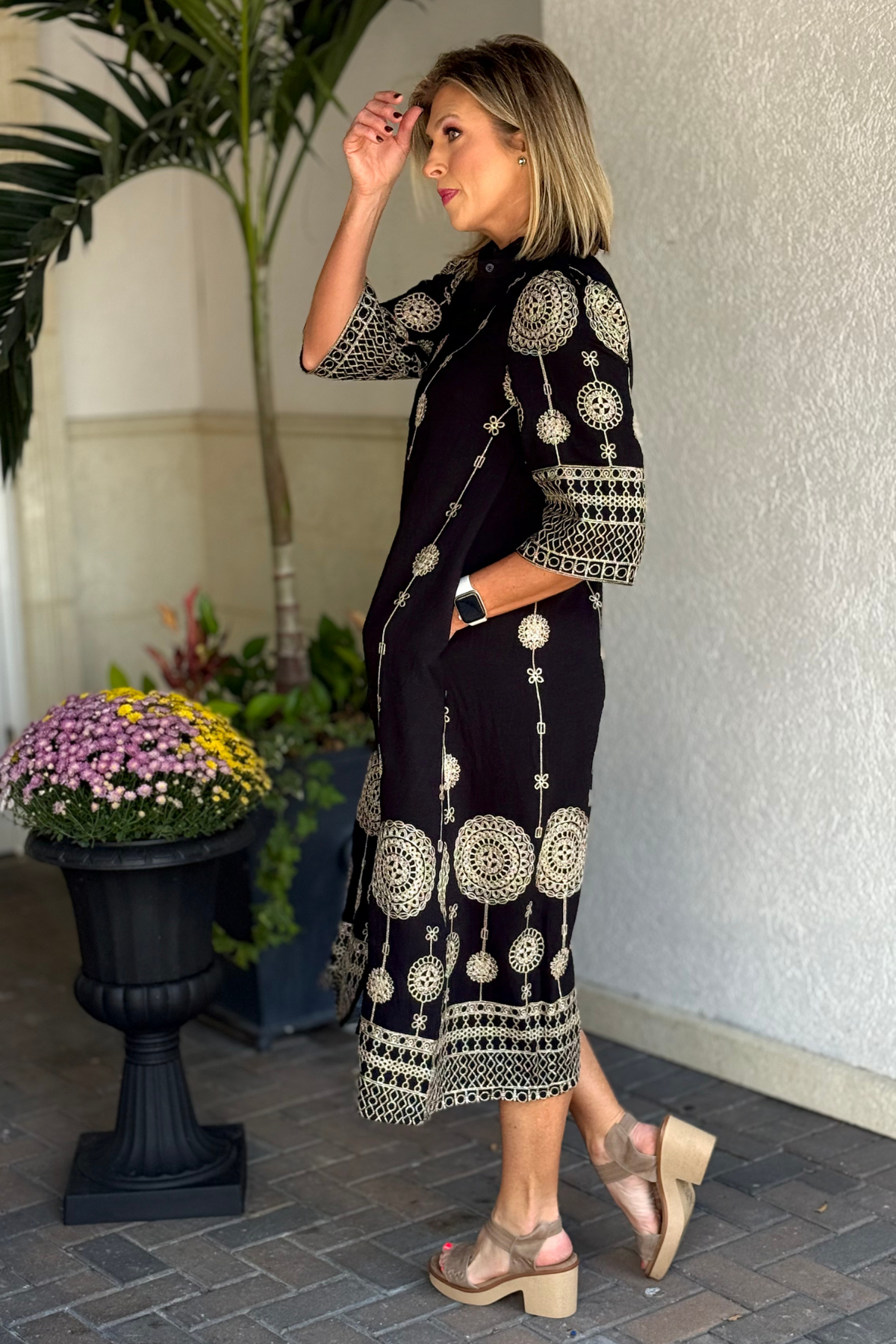 Side view of black button-down embroidered dress with cream detailing